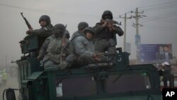 Afghan policemen rush to the scene of Taliban militant attack on main election commission's headquarters, outskirts of Kabul, March 29, 2014.