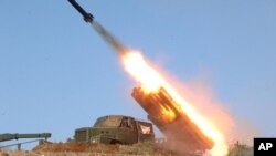 3月14日朝中社发布的照片显示两个岛屿上的炮兵部队在实弹演习中发射火箭