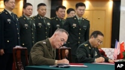 美军参联会主席邓福德上将（前左）与中国中央军委联合参谋部参谋长房峰辉在北京签署协议。 （2017年8月15日）