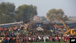 在印度东部一列火车出轨后,救援人员工作,人们围观(2016年11月20日)