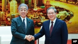 新华社照片​​: 中国国务院总理李强(右)2024年12月25日星期三在北京人民大会堂会见日本外务大臣岩屋毅。