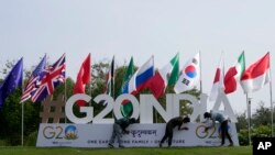 Sejumlah pekerja sedang memasang logo G20 menjelang pertemuan tingkat tinggi kelompok itu di Gandhinagar, India, 13 Juli 2023. (Foto: Ajit Solanki/AP Photo)