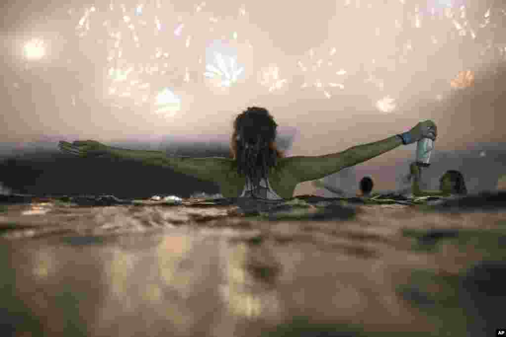 Sheep graze as the full moon, known as the "Super Pink Moon", sets behind Stonehenge stone circle near Amesbury, Britain.