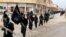 FILE - Fighters from the Islamic State group march in Raqqa, Syria, Jan. 14, 2014.