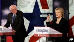 Hillary Rodham Clinton, kanan, saat debat bakal calon presiden Partai Demokrat, sementara Bernie Sanders mendengarkan di Des Moines, Iowa, 15 November 2015.