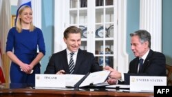 Menlu AS Antony Blinken (kanan) menandatangani perjanjian pertahanan dengan Menteri Pertahanan Finlandia Antti Hakkanen, disaksikan oleh Menlu Finlandia Elina Valtonen di kantor Deplu AS di Washington, DC hari Senin (18/12). 