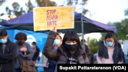 ស្ត្រី​ពលរដ្ឋ​អាមេរិក​ដើម​កំណើត​អាស៊ី​ម្នាក់​លើក​ផ្ទាំង​បដា​មួយ ក្នុង​អំឡុងពេល​នៃ​ការ​គោរព​ដល់​វិញ្ញាណក្ខន្ធ​ជនរងគ្រោះ​ដែល​បាន​ស្លាប់​ដោយសារឧក្រិដ្ឋកម្ម​រើសអើង​ជាតិសាសន៍​​នៅ​ទីក្រុង Alhambra រដ្ឋ California ថ្ងៃទី២១ ខែមីនា ឆ្នាំ២០២១។ 