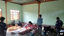 Warga membersihkan jenazah para korban serangan udara di sebuah bangunan di Desa Kanan, Kota Khampat, wilayah Sagaing, Myanmar, Minggu, 7 Januari 2024. (Foto: Associated Press)