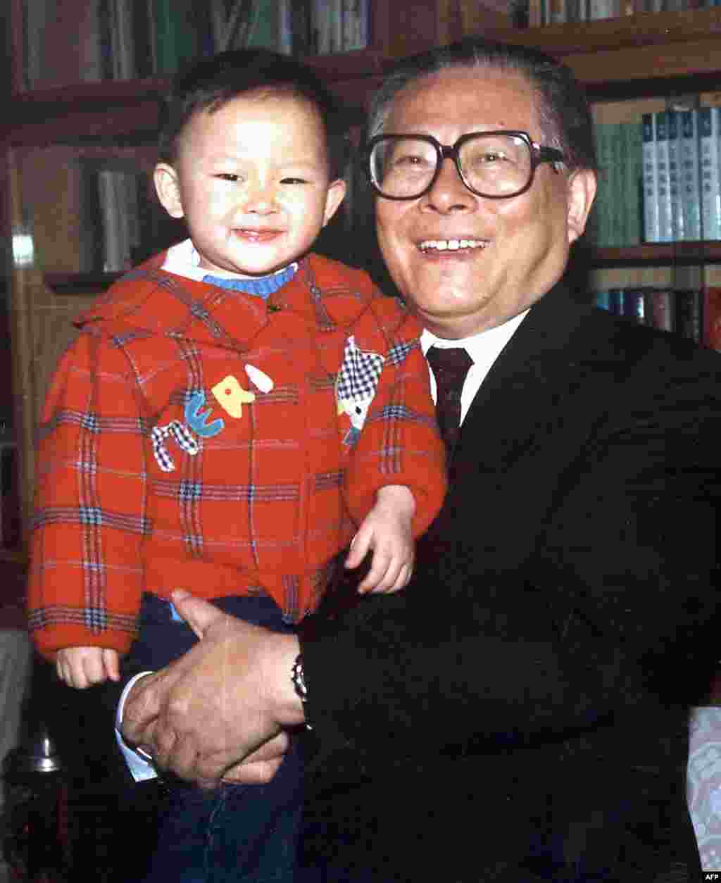 1990年代,中国国家主席江泽民在北京中南海的办公室抱着孙子。法新社说此图拍摄时间不详。本图集编辑估计是1990年代的照片。