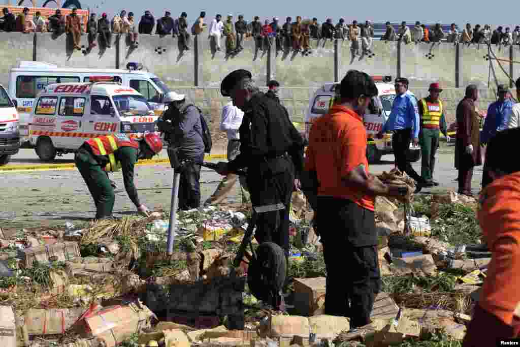 Security officials and rescue workers survey the site of a bomb blast at a vegetable and fruit market in the outskirts of Islamabad, April 9, 2014.