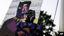 Mason Wilkes, 4 tahun, dari South Carolina mengenakan kostum Black Panther berpose di depan lukisan Chadwick Boseman Tribute, di Anderson, 3 September 2020.