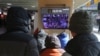 People watch a TV screen showing news coverage of a mob loyal to US President Donald Trump storming the US Capitol, at the Seoul Railway Station in Seoul, South Korea, Jan. 7, 2021.