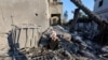 A Palestinian woman sits at the site of an Israeli strike on a house, amid the Israel-Hamas conflict, in Deir al-Balah in the central Gaza Strip, Aug. 7, 2024.