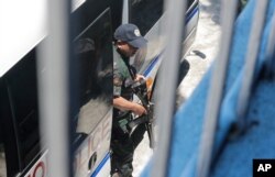 Seorang polisi bersenjata pengawalan Senator oposisi Leila de Lima turun dari kendaraan saat tiba untuk memberikan suara dalam pemilihan paruh waktu negara itu Senin, 13 Mei 2019 di Paranaque, tenggara Manila, Filipina. (Foto: AP)