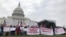 Protestors hold banners in front of Capitol Hill. (Chetra Chap/VOA Khmer) 