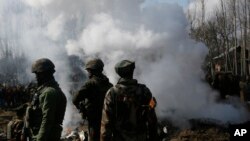 印度军人站在一架印度飞机残骸附近。这架飞机在印控克什米尔地区斯利那加郊外的巴德加姆地区坠毁。(2019年2月27日)