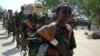 FILE - A youth leads a group of hard-line Islamist al-Shabab fighters as they conduct military exercises in northern Mogadishu's Suqaholaha neighborhood, Somalia, Jan. 1, 2010. 
