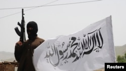 FILE - A Taliban fighter guards an area in Pakistan's South Waziristan tribal region, which borders Afghanistan, May 24, 2008. Sirajuddin Haqqani, the Taliban commander who allegedly operates out of Pakistan, has authored a rare opinion piece.