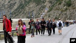 大多数是俄罗斯人2022年9月28日越过格鲁吉亚和俄罗斯之间的边界后行走。他们许多人是为了逃避俄罗斯的征兵令。（美联社照片）