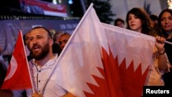 Orang-orang meneriakkan slogan sambil mengenggam bendera Turki dan Qatar selama unjuk rasa untuk mendukung Qatar di Istanbul tengah, Turki, 7 Juni 2017 (foto: REUTERS/Murad Sezer)