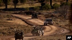 Kendaraan-kendaraan lapis baja Israel bermanuver di zona penyangga setelah melintasi pagar keamanan di dekat Garis Alpha yang memisahkan Dataran Tinggi Golan yang dikuasai Israel dari Suriah, di kota Majdal Shams, 19 Desember 2024. 