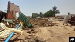 Seorang pria berjalan di samping rumahnya yang hancur akibat banjir yang melanda Meroe, di utara Khartoum, Sudan, pada 20 Agustus 2024. (Foto: AP/Marwan Ali)