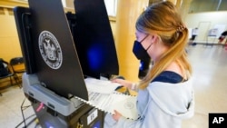 ARHIVA - Džun Harkrajder, koja je napunila 18 godina u martu, stavlja svoj glasački listić u skener dok po prvi put glasa na stranačkim izborima u gradu Njujorku, 14. juna 2021.