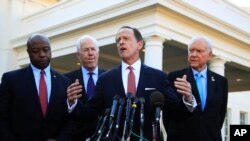 Anggota Komite Keuangan Senat, Senator Patrick Toomey (dua dari kanan) dan dari kiri, Senator Tim Scott, Senator John Cornyn, dan Ketua Orrin Hatch, berbicara kepada para wartawan setelah pertemuan dengan Presiden Donald Trump di Gedung Putih, di Washington, 27 November 2017.