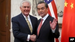 Menlu China, Wang Yi, kanan bersalaman dengan Menlu AS, Rex tillerson, sebelum pertemuan bilateral di Wisma Negara Diaoyutai di Beijing, China hari Sabtu 18 Maret 2017 (foto: AP Photo/Mark Schiefelbein)