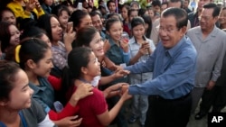 FILE - Cambodia's Prime Minister Hun Sen greets garment workers during a visit to the Phnom Penh Special Economic Zone on the outskirts of Phnom Penh, Cambodia, Aug. 23, 2017. Two Cambodian radio stations said they were being shut down, shrinking the space left for political activity and free expression ahead of next year’s general election.