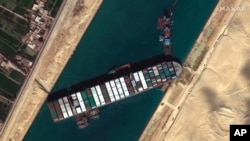 Citra satelit dari Maxar Technologies ini menunjukkan kapal kargo MV Ever Given terjebak di Terusan Suez dekat Suez, Mesir, 27 Maret 2021. (Foto: AP)