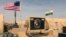 In this photo taken April 16, 2018, a U.S. and Niger flag are raised at the base camp for air forces and other personnel supporting the construction of Niger Air Base 201 in Agadez, Niger. On the edge of the Sahara Desert, the U.S. is building a base for armed drones.