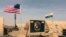 In this photo taken April 16, 2018, a U.S. and Niger flag are raised at the base camp for air forces and other personnel supporting the construction of Niger Air Base 201 in Agadez, Niger. On the edge of the Sahara Desert, the U.S. is building a base for 