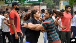 Indian wrestlers Vinesh Phogat, left, and Sangita Phogat practice wrestle as they participate in a protest against Wrestling Federation of India President Brij Bhushan Sharan Singh and other officials in New Delhi, India, April 28, 2023. 