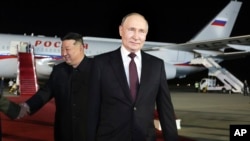 FILE - Russian President Vladimir Putin, right, walks as North Korea's leader Kim Jong Un shakes hands with the Russian delegation during their meeting at the Pyongyang Sunan International Airport outside Pyongyang, North Korea, early Wednesday, June 19, 2024.
