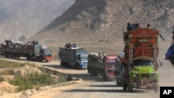 FILE - Trucks carrying Afghan families move toward a border crossing at Torkham, Pakistan, Oct. 31, 2023. Pakistan launched a repatriation program in October 2023 after a spike in violence that Islamabad blamed on militants operating from Afghanistan.