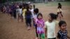 Children wait to receive gifts after a show to entertain them at the sports club where Central American migrants traveling with the annual Stations of the Cross caravan have been camped out in Matias Romero, Mexico, April 4, 2018. 
