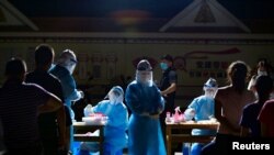 资料照:云南医护人员在与缅甸接壤的边境城市瑞丽的一个居民区进行新冠病毒核酸检测。(2020年9月16日)