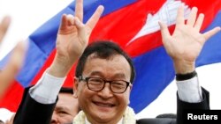 Sam Rainsy, president of the National Rescue Party, greets his supporters in Phnom Penh, July 19, 2013. 