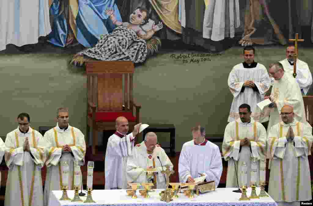 Pope Francis (C) leads an open-air mass at Manger Square in the West Bank town of Bethlehem, May 25, 2014. Pope Francis made an impassioned plea for peace on a pilgrimage on Sunday to Bethlehem, the traditional birthplace of Jesus, urging an intensified effort to end the Israeli-Palestinian conflict.