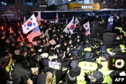 Para polisi berjaga saat pendukung pro-Yoon mencoba memasuki kompleks Pengadilan Distrik Seoul Barat di Seoul, Sabtu, 18 Januari 2025. (Foto: Jung Yeon-je/AFP)