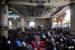 Palestinians gather inside a war-damaged mosque to perform the Friday noon prayer during the Muslim holy fasting month of Ramadan, in the Nuseirat refugee camp in the central Gaza Strip on March 7, 2025.