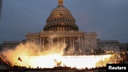 Ledakan yang disebabkan oleh amunisi polisi tampak di depan gedung Capitol sementara massa pendukung Presiden Donald Trump berkumpul di depan gedung tersebut di Washington, Rabu, 6 Januari 2021. (Foto: Reuters)