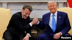 U.S. President Donald Trump and French President Emmanuel Macron react during their meeting at the White House in Washington.