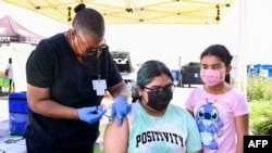 Brenda Vargas, 14 tahun, menerima suntikan vaksin COVID-19 dari Pfizer di di sebuah klinik di Los Angeles, 16 Juli 2021. 