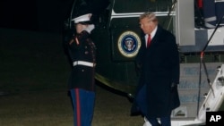 FILE - President Donald Trump greets a Marine Corps honor guard as he disembarks Marine One upon arrival on the South Lawn of the White House in Washington, Jan. 27, 2025.
