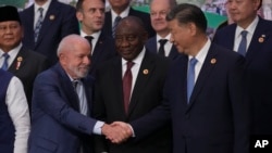 Brazil's President Luiz Inacio Lula da Silva, left, shakes hands with China's President Xi Jinping as they gather for a G20 Summit world leaders' group photo, in Rio de Janeiro, Nov. 19, 2024.