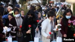 Warga berkumpul untuk menyalakan lilin setelah penembakan massal selama perayaan Tahun Baru Imlek di Monterey Park, California, AS, 24 Januari 2023. 