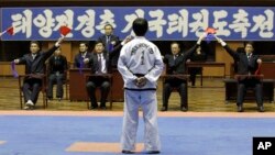 FILE - A North Korean participant in a national Taekwondo festival is judged in front of a sign in Korean that reads “National Taekwondo Festival for Celebrating Day of the Sun” at the Taekwondo Hall in Pyongyang, North Korea, April 7, 2012.
