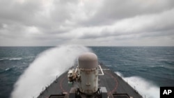 In this photo provided by the U.S. Navy, the guided-missile destroyer USS John S. McCain conducts routine underway operations in support of stability and security for a free and open Indo-Pacific, at the Taiwan Strait, Dec. 30, 2020.
